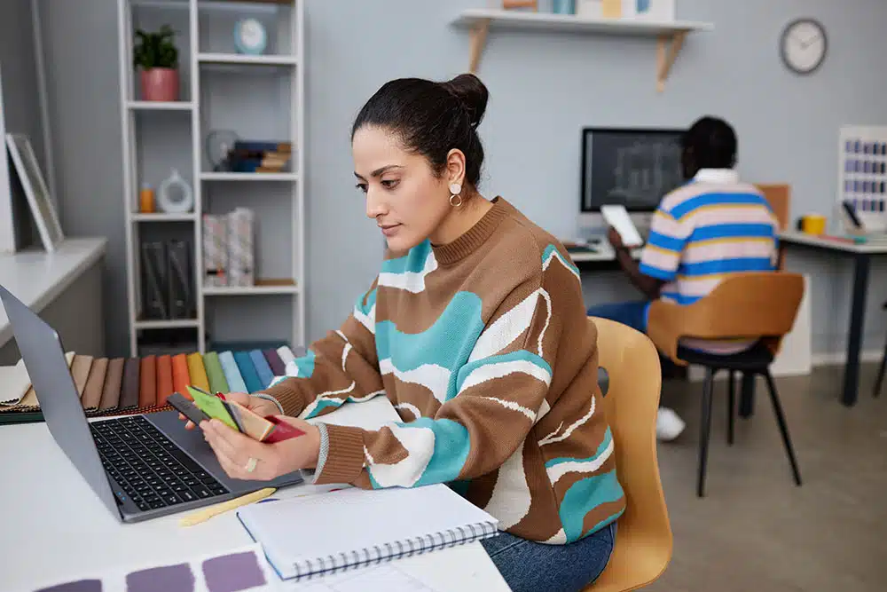 Female designer engrossed in design work, on her laptop
