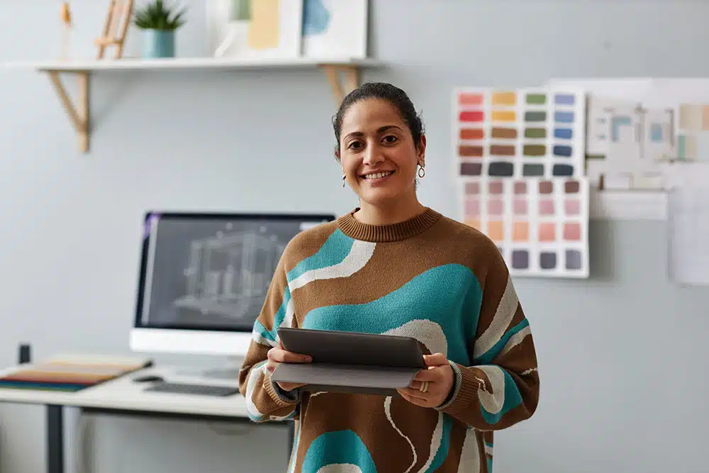 Female technical creative worker refers to designs and data on her tablet